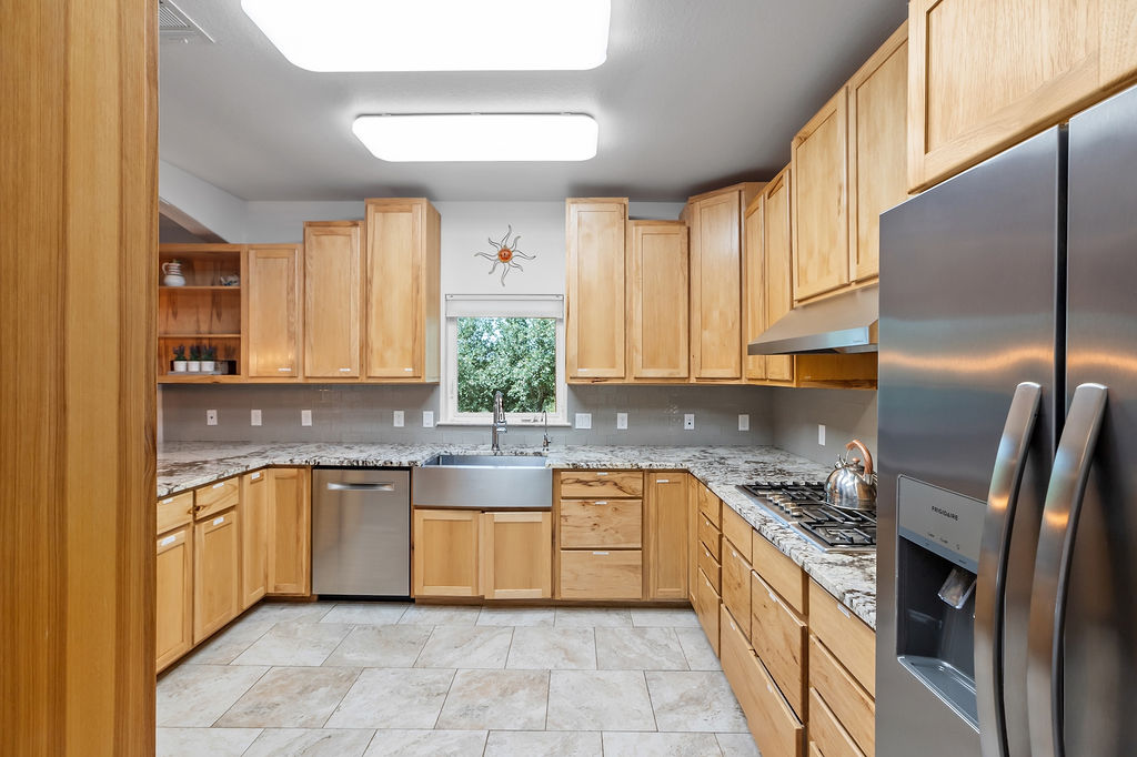 13326 Trautwein Road Austin, TX 78737 - Photo 5 of 40 a kitchen with stainless steel appliances granite countertop a sink a stove and a refrigerator
