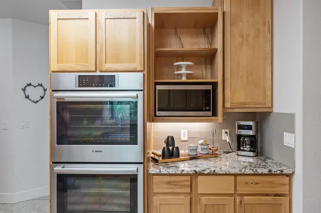 a kitchen with granite countertop cabinets stainless steel appliances and a sink