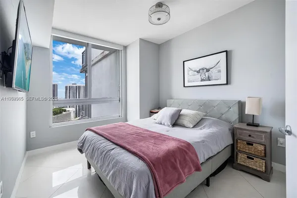 a bedroom with a bed and a painting on the wall