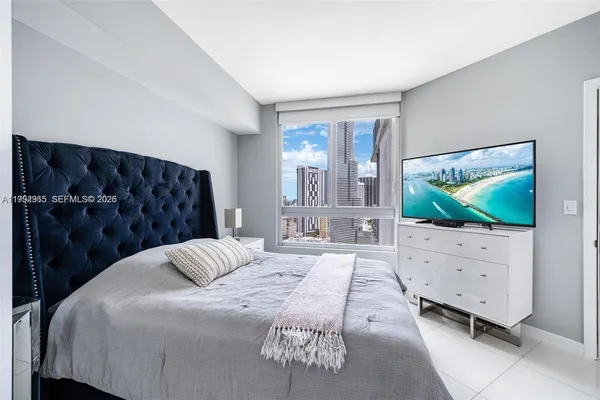 a bedroom with a bed and a flat screen tv