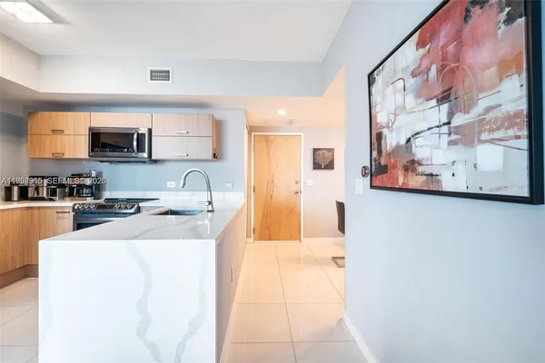 a kitchen with stainless steel appliances a sink a stove top oven a counter top space and cabinets
