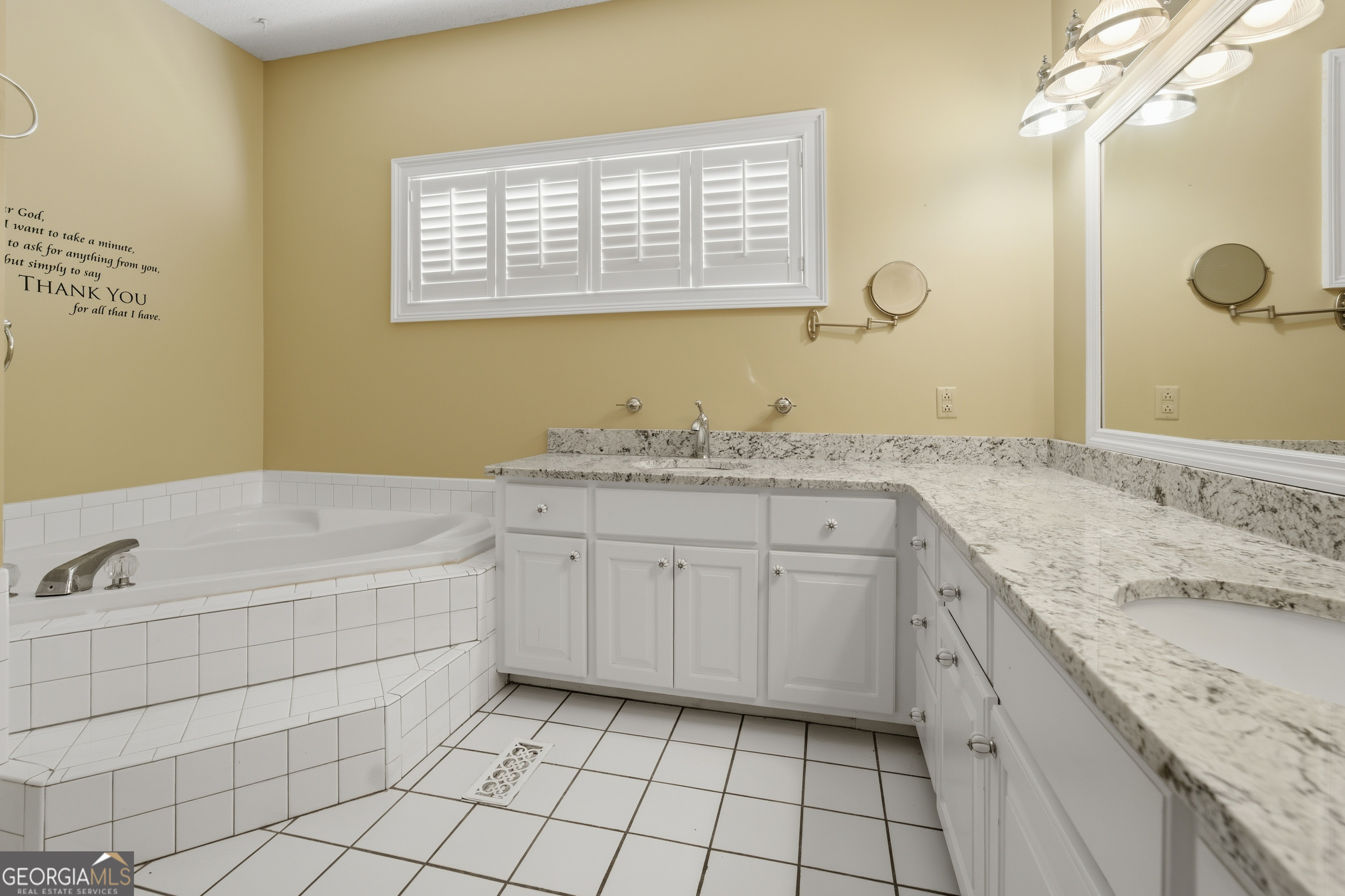 134 Patrick Street Swainsboro, GA 30401 - Photo 30 of 57 a spacious bathroom with a granite countertop sink a mirror and a bathtub