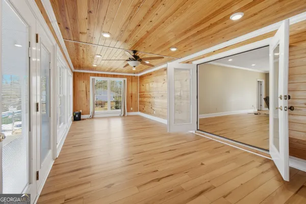 an empty room with wooden floor and windows