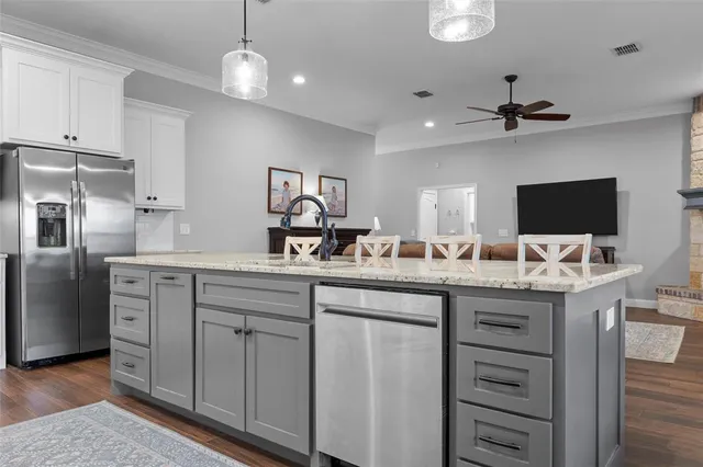 a kitchen with cabinets a center island and stainless steel appliances