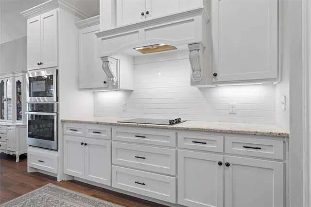 a kitchen with white cabinets and sink