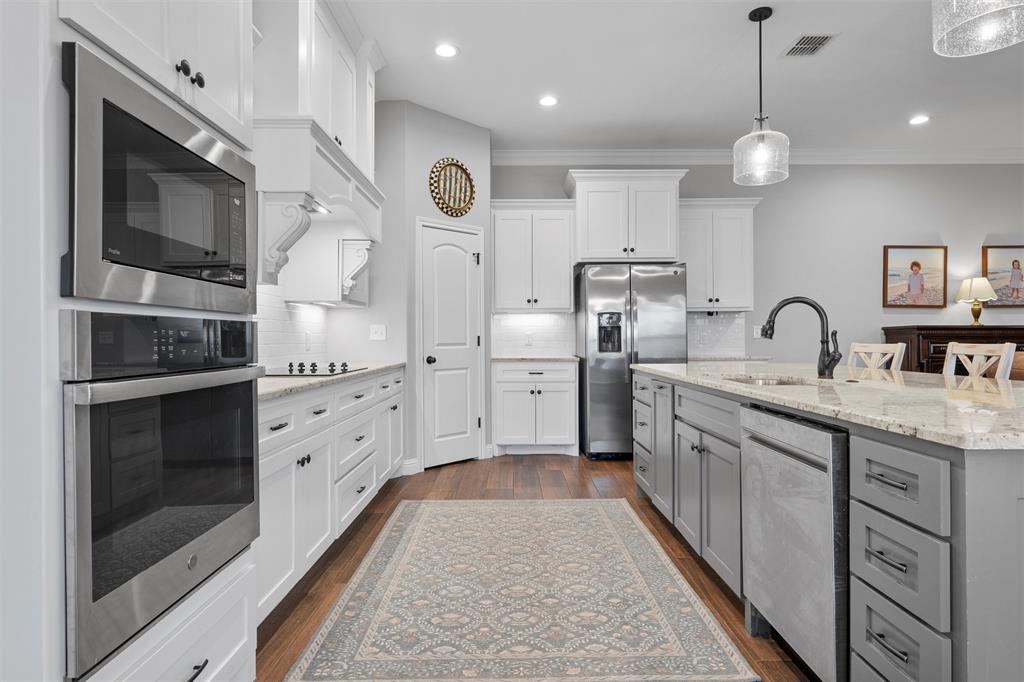 717 Wintergreen Drive Hewitt, TX 76643 - Photo 10 of 33 a kitchen with stainless steel appliances granite countertop a sink and a stove top oven