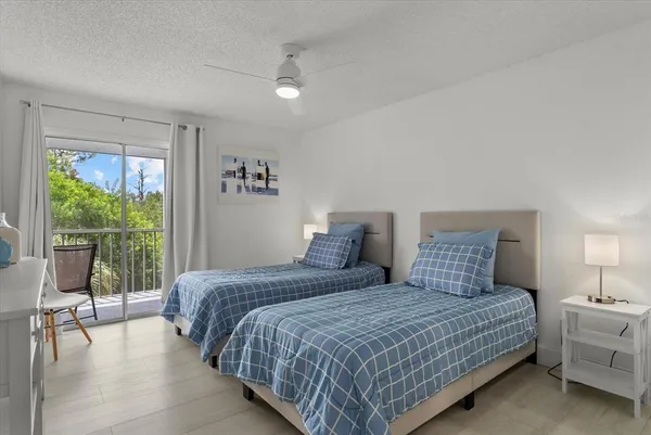 a bedroom with a bed and large windows