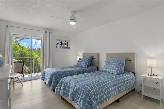 a bedroom with a bed and large windows