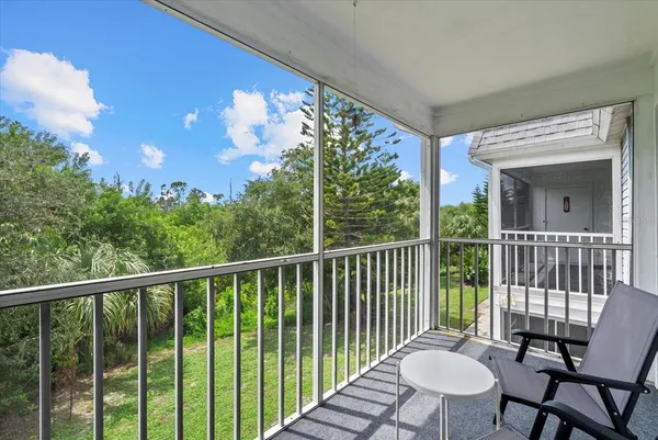 a view of a balcony with wooden floor table and chairs