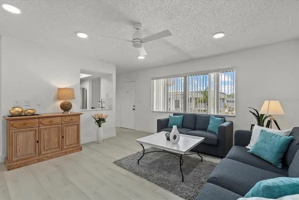 a living room with furniture a rug and a large window