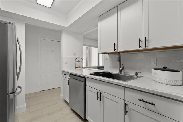 a kitchen with stainless steel appliances a sink and cabinets
