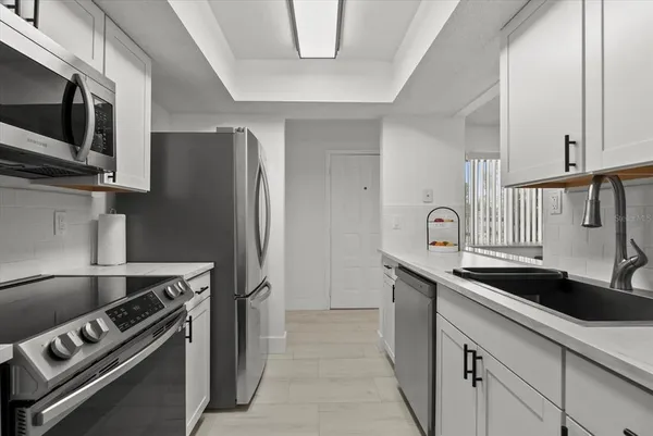 a kitchen with stainless steel appliances granite countertop a sink and a refrigerator