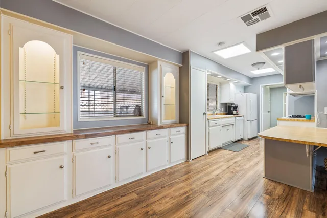 a kitchen with cabinets and wooden floor