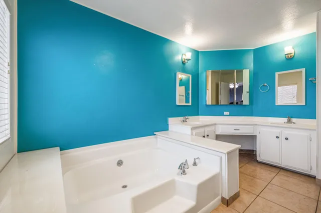 a bathroom with a granite countertop sink and a large window