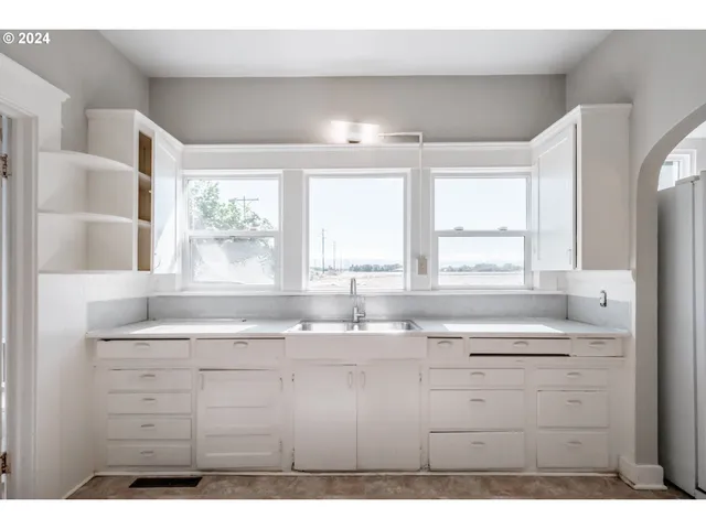 a kitchen with a sink window and cabinets