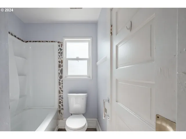 a bathroom with a toilet and a shower