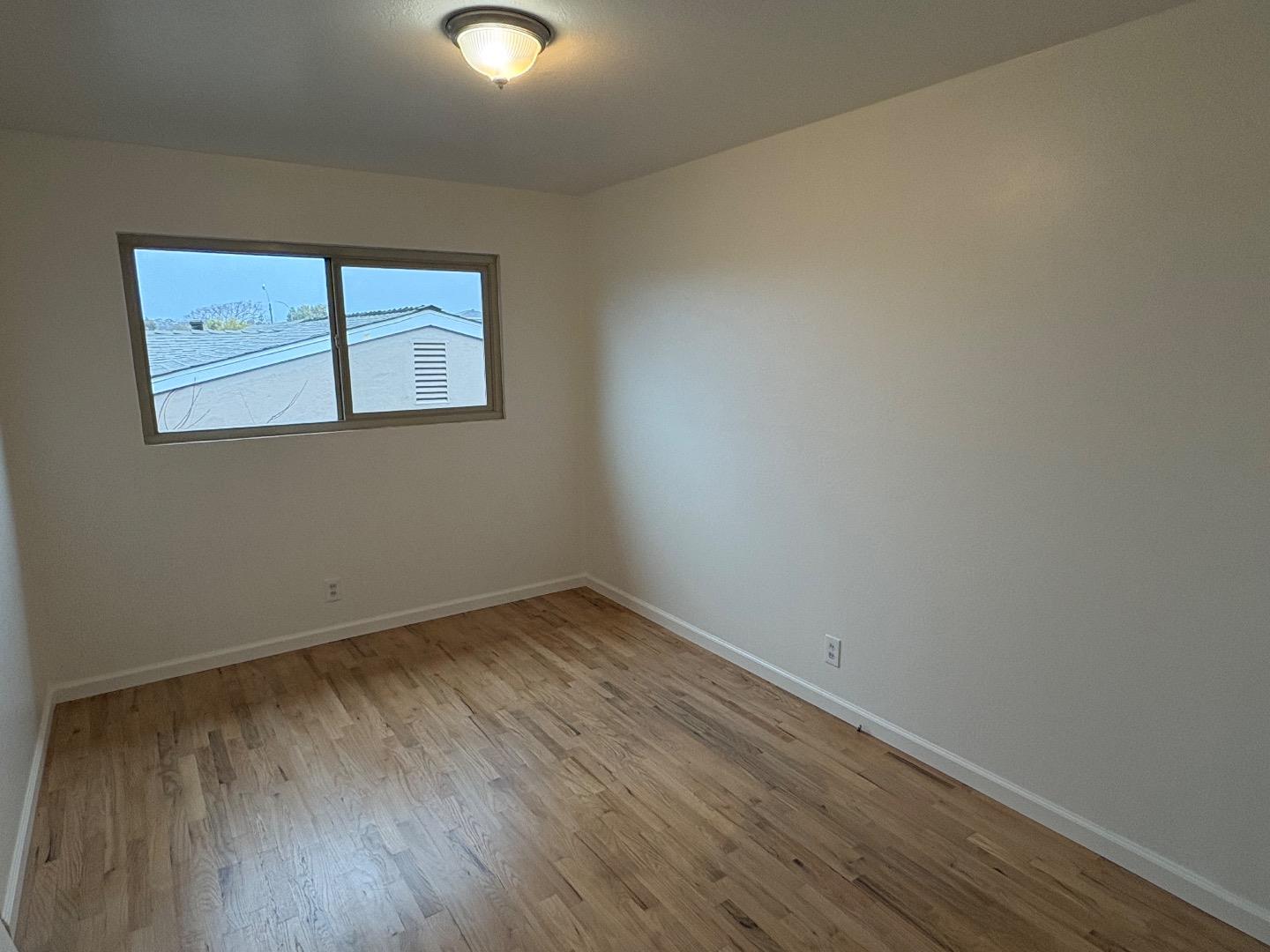 1675 Luxton Street Seaside, CA 93955 - Photo 25 of 33 a view of an empty room with wooden floor and a window