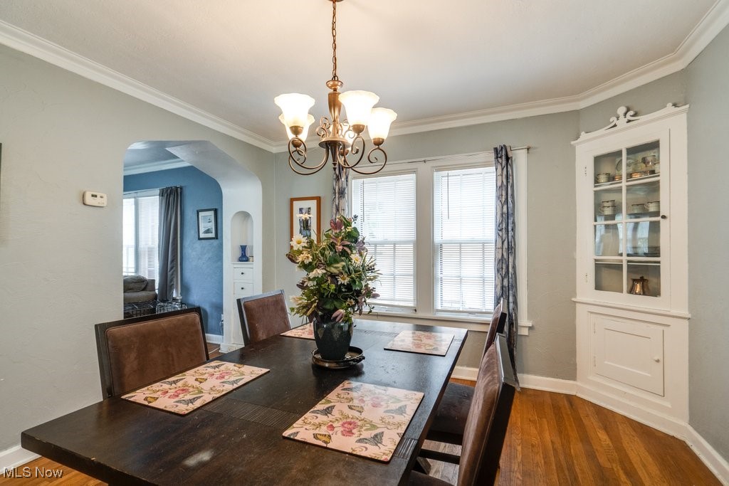 3709 Strandhill Road Shaker Heights, OH 44122 - Photo 9 of 25 Dining area with a wealth of natural light, an inviting chandelier, hardwood / wood-style floors, and crown molding