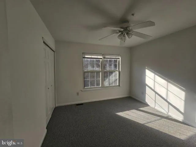 a view of a room with a ceiling fan and window