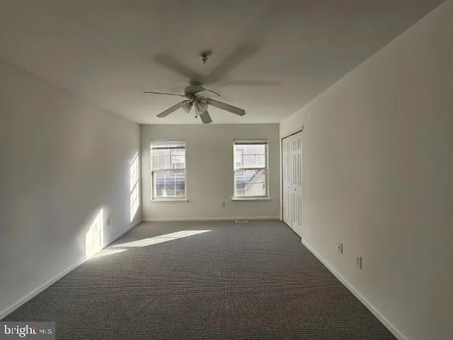 an empty room with a ceiling fan and bathroom