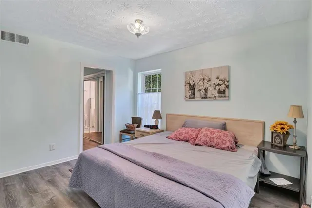 a bedroom with a bed and a lamp on dresser