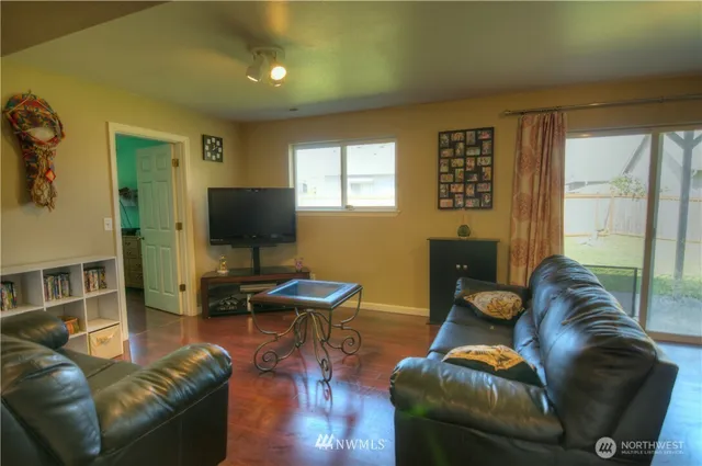 a living room with furniture and a wooden floor