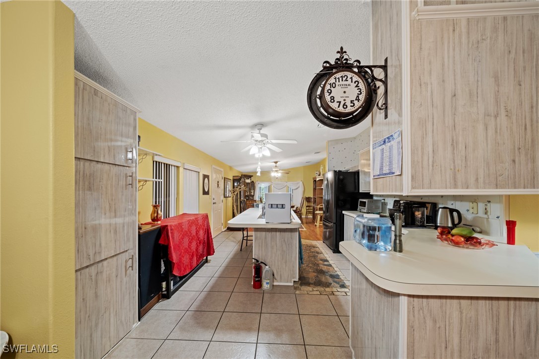 919 Manatee Road Naples, FL 34114 - Photo 12 of 32 a kitchen with a stove a clock and cabinets