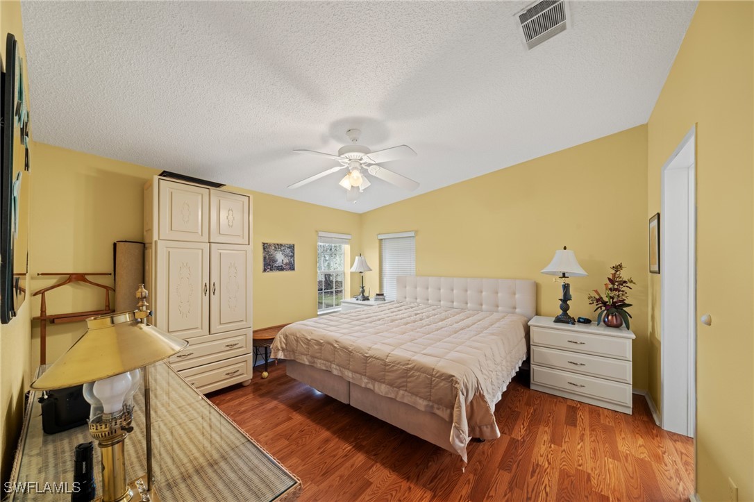 919 Manatee Road Naples, FL 34114 - Photo 17 of 32 a bedroom with a bed and wooden floor