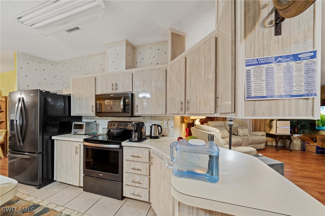 919 Manatee Road Naples, FL 34114 - Photo 7 of 32 a kitchen with a sink a stove a refrigerator and cabinets