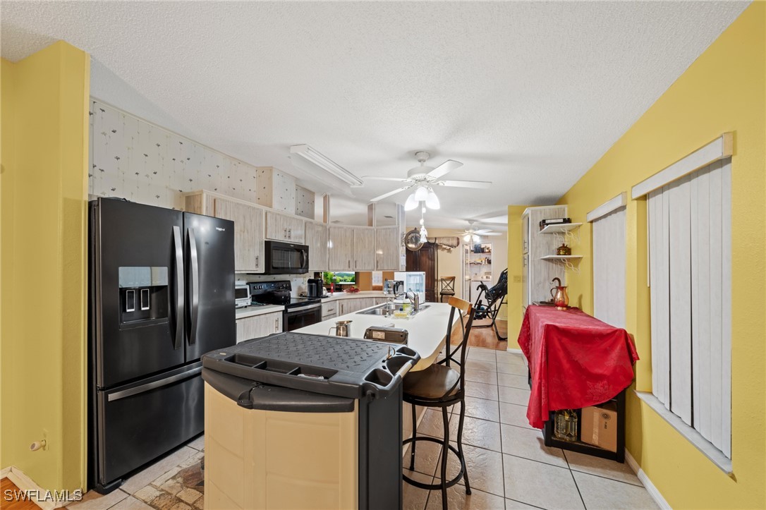 919 Manatee Road Naples, FL 34114 - Photo 8 of 32 a view of a kitchen with refrigerator and dining table