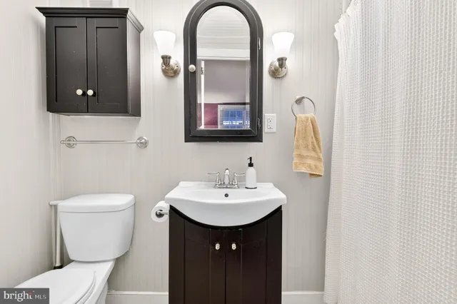a bathroom with a toilet sink and mirror