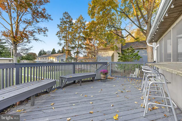 a view of deck with wooden floor and fence and a trees