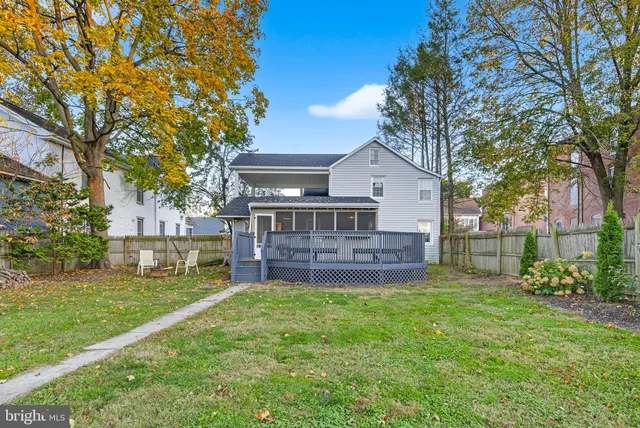 a view of a house with a big yard and a large tree