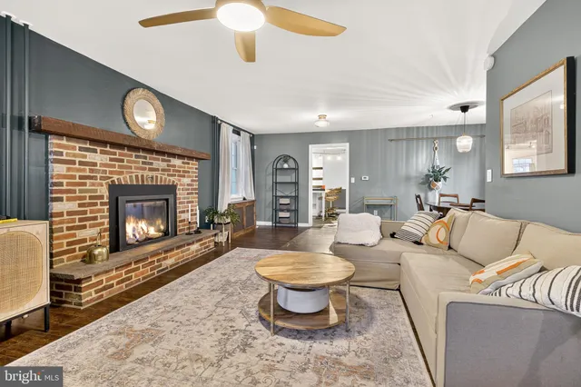 a living room with furniture a fireplace and a large window