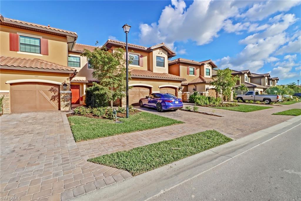 9653 Montelanico Loop, Unit 102 Naples, FL 34119 - Photo 1 of 26 front view of a house with a street