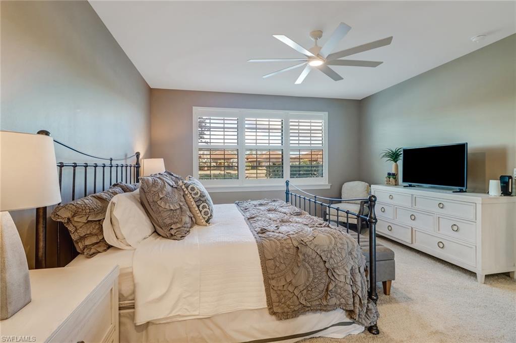 9653 Montelanico Loop, Unit 102 Naples, FL 34119 - Photo 15 of 26 a bedroom with furniture and a flat screen tv