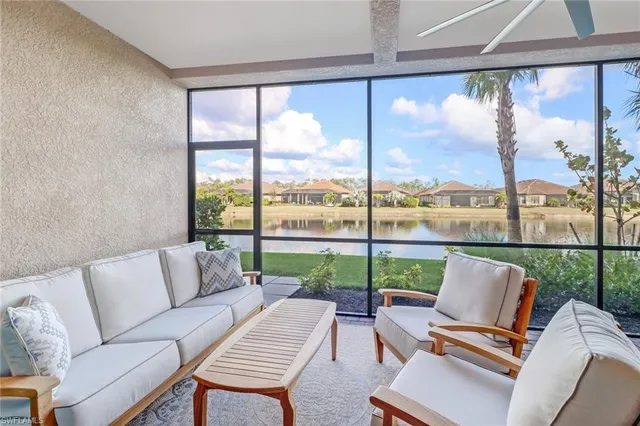 a living room with patio furniture and a floor to ceiling window