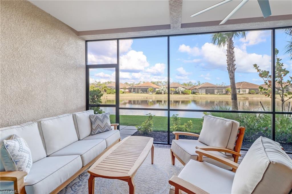 9653 Montelanico Loop, Unit 102 Naples, FL 34119 - Photo 22 of 26 a living room with patio furniture and a floor to ceiling window