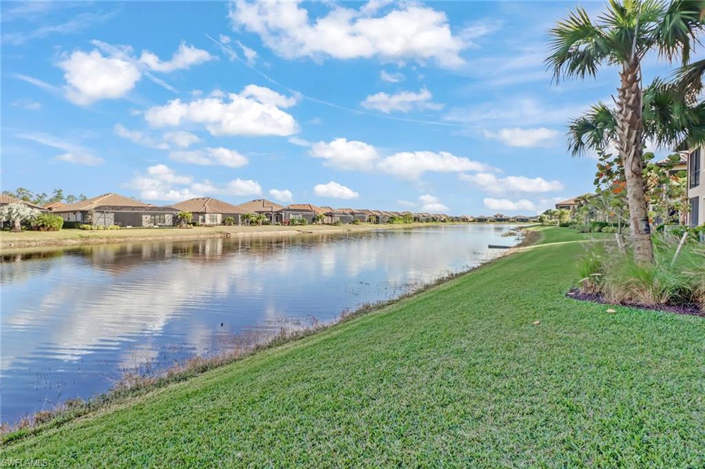 9653 Montelanico Loop, Unit 102 Naples, FL 34119 - Photo 23 of 26 a view of a lake with houses in the back