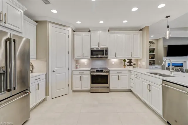 a kitchen with stainless steel appliances granite countertop a refrigerator and a stove top oven