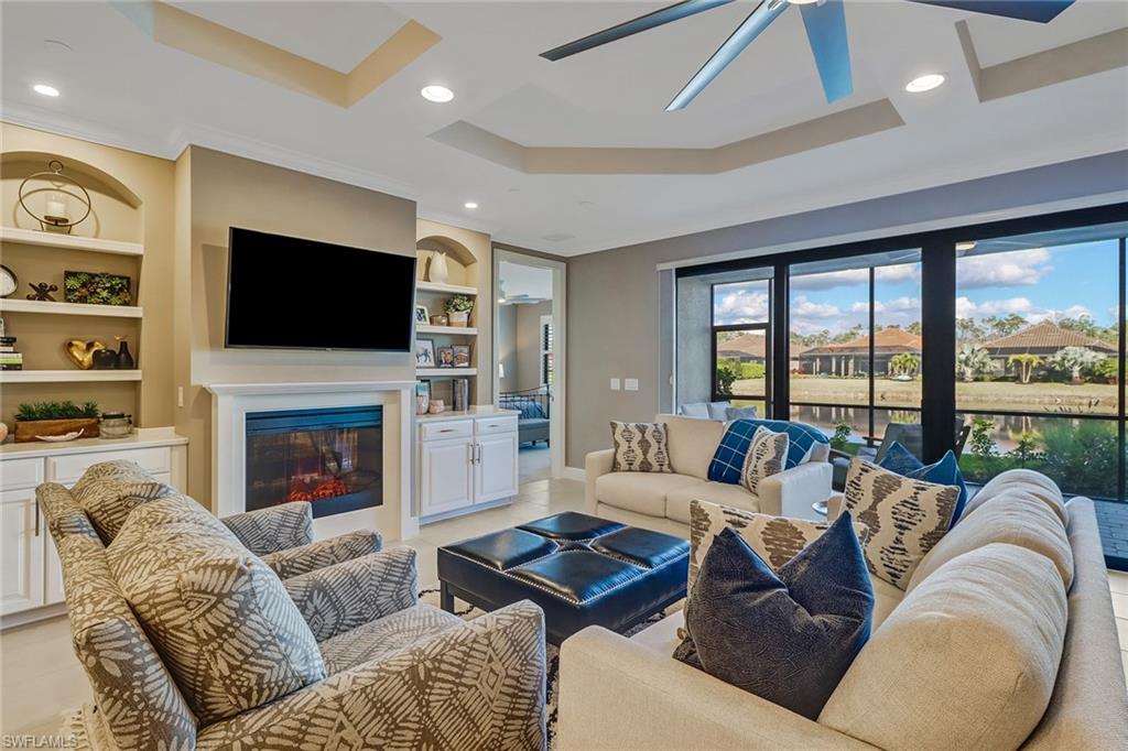 9653 Montelanico Loop, Unit 102 Naples, FL 34119 - Photo 7 of 26 a living room with furniture a fireplace and a flat screen tv