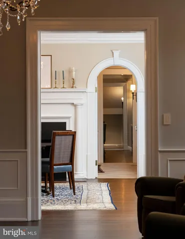 a dining room with furniture a chandelier and wooden floor