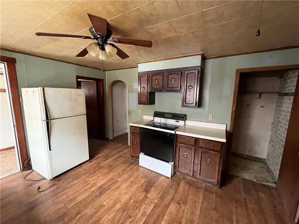 a kitchen with stainless steel appliances a refrigerator and wooden floor