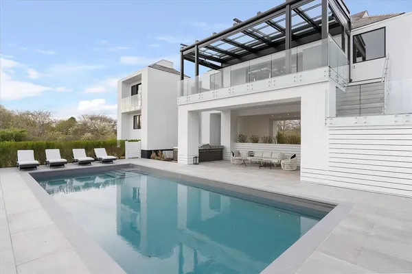 a view of a house with pool and chairs