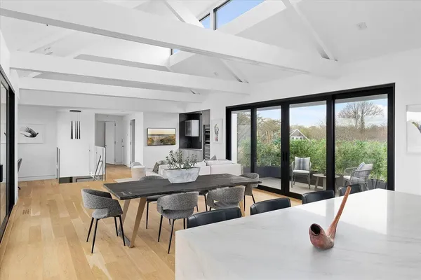 a view of a dining room with furniture large windows and wooden floor