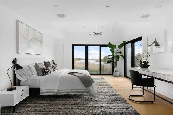 a bedroom with a bed a large window and furniture