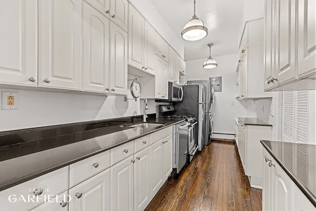a kitchen with stainless steel appliances sink stove top oven and cabinets