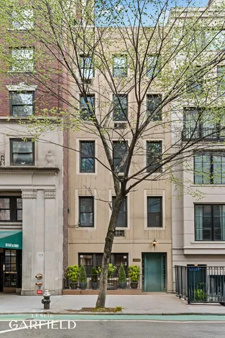 a front view of a building with trees