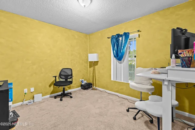 a view of a workspace with a table and chairs