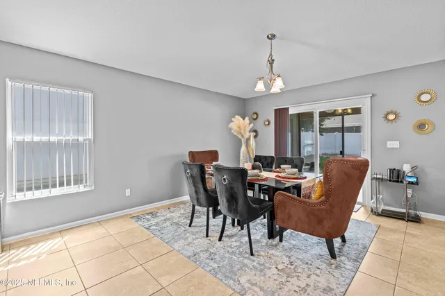 a dining room with furniture a chandelier and wooden floor